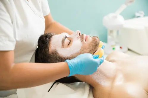female-therapist-washing-face-male-customer-while-giving-facial-spa_662251-2556